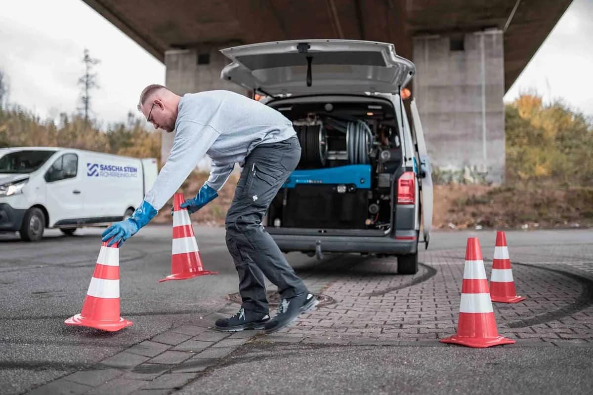 Techniker der Sascha Stein Rohrreinigung sichert die Einsatzstelle mit Pylonen ab