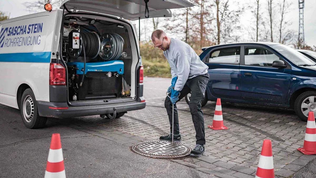Techniker der Sascha Stein Rohrreinigung öffnet einen Kanalschacht